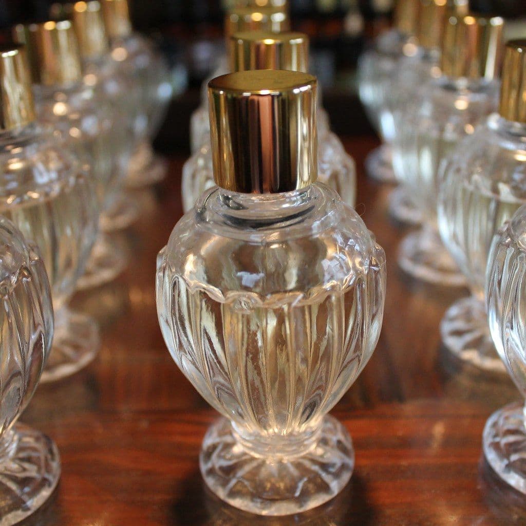 A crystal perfume bottle with a gold cap
